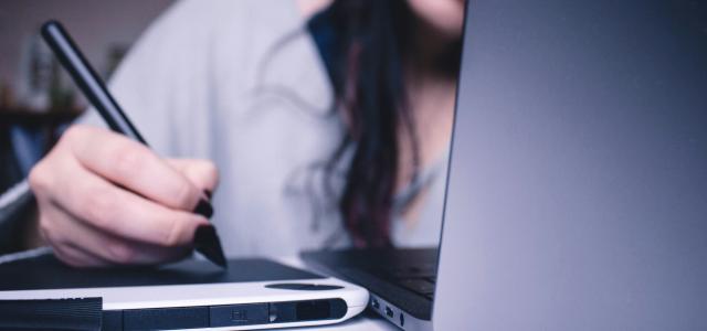 woman using drawing pad while sitting in front of laptop by Josefa  nDiaz courtesy of Unsplash.